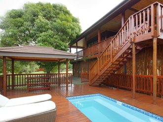 A house built on stilts, with pool and braai area