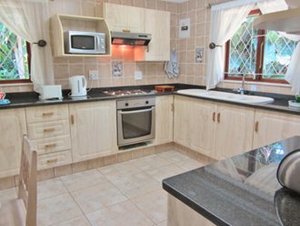 Kitchen With Porcelain Tiles, Granite Tops, Built-in Oven And Hob, Microwave, Cooker-hood And Double Sink. Fridgefreezer Not Visible In This Photo